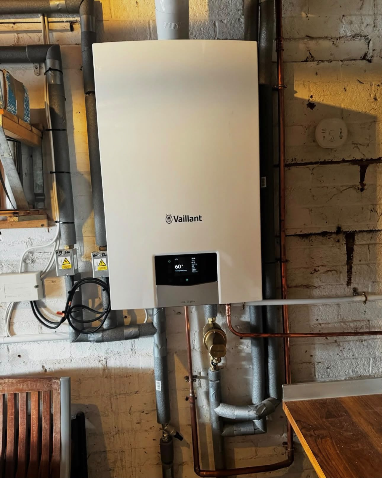 Wall-mounted Vaillant boiler installation with insulated pipework and copper connections